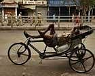 A rickshaw puller sleeps as a wholesale market remains closed, background, during a strike call by opposition parties in New Delhi, India, Monday . AP