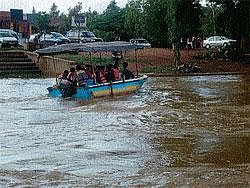 Tribals being ferried in a private boat near Dubare in Kushalnagar.  DH Photo