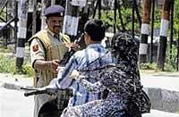 A paramilitary trooper stops a couple on a scooter at Lal Chowk in Srinagar on Monday. AFP