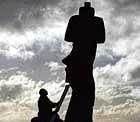 A man repairs a Moais  stone statues of the Rapa Nui culture  on the Easter Island, 3,700 km off the Chilean coast in the Pacific Ocean, on Friday. Hundreds of scientists, tourists and locals expect to see from the Easter Island the almost five-minute total eclipse that will take place on Sunday. AFP