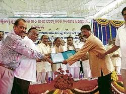 Union Minister of State for Railways K H Muniyappa, district in-charge minister Dr Mumtaz Ali Khan and others handing over records relating to land identified for setting up a mega dairy, to Komul members in Chikkaballapur on Sunday. Legislator K P Bachegowda and KMF president Somasekhara Reddy are seen.  dh photo
