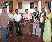 Sri Kshethra Dharmasthala Rural Development Project                District Director Jayaram Nellithaya distributing cheques to banana growers who lost the crop due to natural calamity, at Bastimata in N R Pura on Saturday.  DH Photo