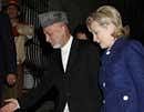 Afghan President Hamid Karzai, (C), shows the way to U.S. Secretary of State Hillary Clinton after her arrival at the presidential palace in Kabul Afghanistan. AFP