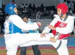Skill and grit: Karnatakas Tejaswini (right) en route to her win over SAI LNCPEs Huiyam Dolly Devi in the womens Senior  under-53 category in the South Zone Teakwondo Championship at the Sree Kanteerava Stadium on Friday. DH photo