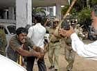 violence begets violence: A member of Karnataka Rakshana Vedike attacks police during a protest in front of the DC office in Bangalore on Saturday.