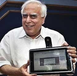 Human Resource Development Minister Kapil Sibal displays a low-cost tablet at its launch in New Delhi on Thursday July 22. The device looks like an iPad and is 1/14th the cost. India has unveiled the prototype of a US$35 basic touch screen tablet aimed at students, which it hopes to bring into production by 2011. AP