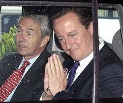 In this handout photograph provided by the Karnataka state, Raj Bhavan, British Prime Minister David Cameron, right, gestures as he leaves the residence of the Karnataka state Governor, in Bangalore, India, Wednesday.