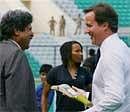 : British Prime Minister David Cameron talks with former cricketer Kapil Dev during a visit to Major Dhyan Chand National Stadium in New Delhi on Thursday. PTI