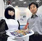 A house maid-shaped guide robot delivers giveaway chocolates to guests during a demonstration at a Robotech exhibition in Tokyo. AFP