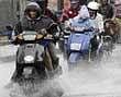 Two-wheeler riders wading through the waterlogged Rajkumar Road in Rajajinagar.