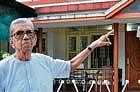 Mark Rodrigues pointing at a diffused bomb shell implanted on his compound wall in Alvares Road, Kadri.