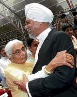 The new Chief Justice of Karnataka Jagdish Singh Khehar is hugged by his mother Satpal Kaur after the oath-taking ceremony at Raj Bhavan in Bangalore on Sunday. DH Photo