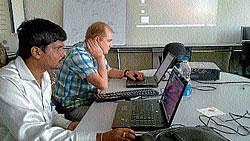 Prof  Kirill Krinkin and lecturer Shivaprakash verifying  students projects at SJCE in Mysore.