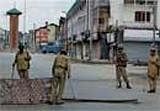 Central Reserve Police Force soldiers stand guard at closed main road of Lal Chowk of a deserted street in curfew-bound street of Srinagar on Tuesday. PTI