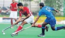 P Kalyan Kumar (left) of PCTC moves past Ramesh of KSP in the Travancore Cup hockey meet.  DH photo