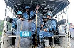 Rapid Action Force personnel wear blue helmets and shields with United Nations insignia in Srinagar. AP