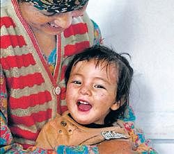 Destinys child: The two-and-half year-old miracle baby, Deldan Anjmo, smiles as she sits on her mothers lap after recovering at an Army hospital in Leh on Thursday. Anjmo, was found floating in the water by jawans with her eyes and mouth full of slush. PTI