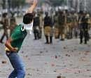 A  Kashmiri protester throws stones at paramilitary soldiers during a protest in Srinagar on Friday. AP