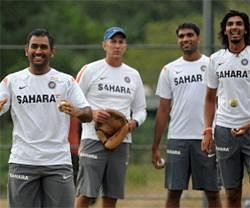 Indian cricket captain Mahendra Singh Dhoni (L) shares a light moment with teammate Virat Kohli (unseen) as bowling coach Eric Simmons (2 L), Munaf Patel (2 R) and Ishant Sharma (R) look on at a practice session at Dambulla, Sri Lanka. AFP photo