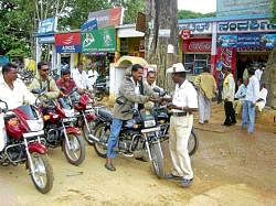 A traffic constable seen slapping fines on violators in Chikkaballapur. DH photo