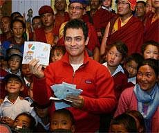 Aamir Khan showing the greeting cards presented to him by the children during a visit to Druk Padma school where his film '3 Idiots' was shot, at Shey in Leh on Wednesday. PTI
