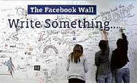 On  A High: Facebook employees write on the wall following a news conference  in Palo Alto, California on Wednesday, to  announce the launch of Facebook Places. AFP