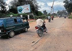 A rider tries his best to avoid riding over a hump on KRS road in Mysore. dh photo
