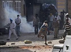Kashmiri protesters throw stones at an Indian police vehicle during a protest in Srinagar. Tens of thousands of residents in Indian Kashmir on Friday protested against New Delhi's rule across the disputed region after the death of two people in firing by government forces. AP