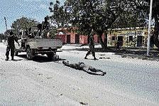 Government forces drag the body of an alleged Islamist  fighter along the streets of Mogadishu on Tuesday. AFP