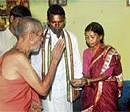 Benediction: Pejawar Mutt seer Vishwesha Theertha at a Dalit home during his visit to  Devaraj Urs Slum Colony in Mysore on Friday. DH Photo