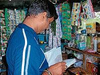 Manjanna browsing accounts of customers at his shop in Mysore.  Dh photos