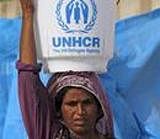 A woman walks back to her tent after getting water from nearby point in a camp for flood-affected people in Sukkur, in southern Pakistan. AP