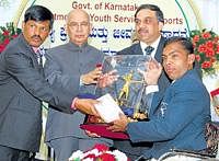 Disabled athlete Raghavendra Ratnakar Anvekar (right) rec-eives the Ekalavya award from Governer HR Bharadwaj (sec-ond from left) on Sunday as Sports Minister Goolihatti D Sh-ekhar (left) and KOA President K Govindaraj look on. DH photo