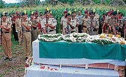 BSF personnel giving gun salute to slain soldier K P Lokesh at Karigowdanakoppal in Hassan on Monday. DH Photo
