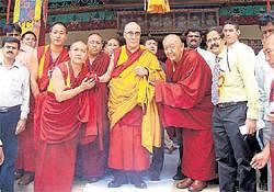 Buddhist monks welcome the Dalai Lama at the Tibetan camp in Bylakuppe on Tuesday. DH Photo