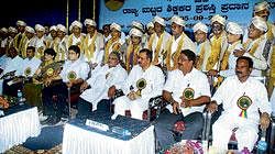 One for the album: Award-winning teachers pose for a photo session at the State-level Teachers Day programme in Mysore on Sunday. Minister for Primary and Secondary Education Vishweshwara Hegde Kageri, Deputy Commissioner Harsh Gupta, MLC G Madhusudhan, MLA Tanveer Sait and others look on. DH Photo