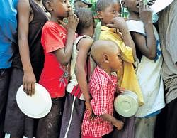 Dealing with hunger:  Children wait for rice and beans distributed by the Haitian government in Port-au-Prince. NYT