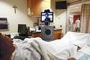 ARTIFICIAL INTELLIGENCE: Dr John Whapham, a neurologist pictured in the monitor of a mobile robot, sometimes called a telepresence robot, speaks with a patient at Loyola University Medical Centre in Maywood, Illinois. NYT