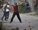 Stones in hand, a Kashmiri protester dares Indian policemen to shoot him during a protest in Srinagar, India, Wednesday, Sept. 8, 2010.