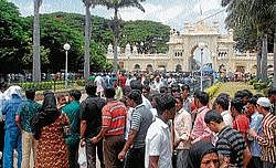 Tourists making a beeline to buy entry ticket to Palace, in Mysore on Sunday. A long queue was witnessed throughout the day outside the ticekt counter, even as thousands thronged the palace. dh photo