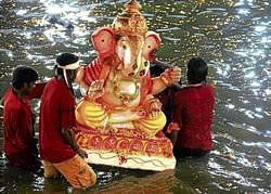 An idol of Ganesha being immersed in Yediyur Lake on Saturday night. DH photo