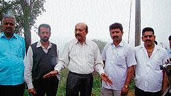 MLC M C Nanaiah speaking to presspersons after inspecting the encroached government land in Madikeri. DH PHOTO