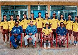 Players of the University of Mysore Kho-Kho team led by Captain Nalina T N posing with manager Sandhya Rani, coach B D Kantharaju, and Director of Physical Education, Dr C Krishna in Mysore on Monday. DH PHOTO