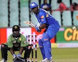 Mumbai Indians batsman Kieron Pollard (R) plays a stroke from Guyana bowler Devindra Bishoo (not pictured) as Guyana wicketkeeper Derwin Christian (L) waits to make a catch during the Twenty20 Champions League match between the Mumbai Indians and Guyana at the Kingsmead Stadium in Durban, South Africa . AFP
