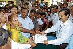 Returning Officer Amaresh Naik handing over the certificate to JD(S) candidate Aruna Patil Revoor who won the bypoll in Gulbarga South on Thursday. JD(S) State president H D Kumaraswamy seen rejoicing the success of party candidate. dh photo