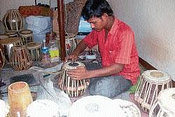 Ganesh from Nalagunda giving final touches to the instrument in Bombay Harmonium Works at Car Street. DH Photo/Author