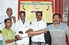 Vyavasaya Seva Sahakara Sanghas president H P Narayana Reddy disbursing loan cheques to an entitled woman at Chikkapalyagurki in Chikkaballapur taluk. Sanghas Secretary M R Narayanaswamy and others are seen. dh photo