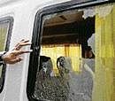 An official inspects the shattered window of a bus suspected to have been attacked by gunmen near Jama Masjid in  New Delhi on Sunday. AP