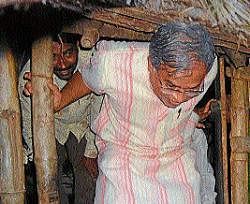 taking stock: District Incharge Minister Suresh Kumar comes out of a tribal hut, in Masthamma haadi, in Hunsur on Sunday. Dh photo