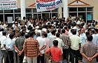 The ire: Angry traders of the Visvesvaraya road laying siege to the City Municipal Council  office demanding early re-laying of footpath, in Mandya on Wednesday. DH Photo